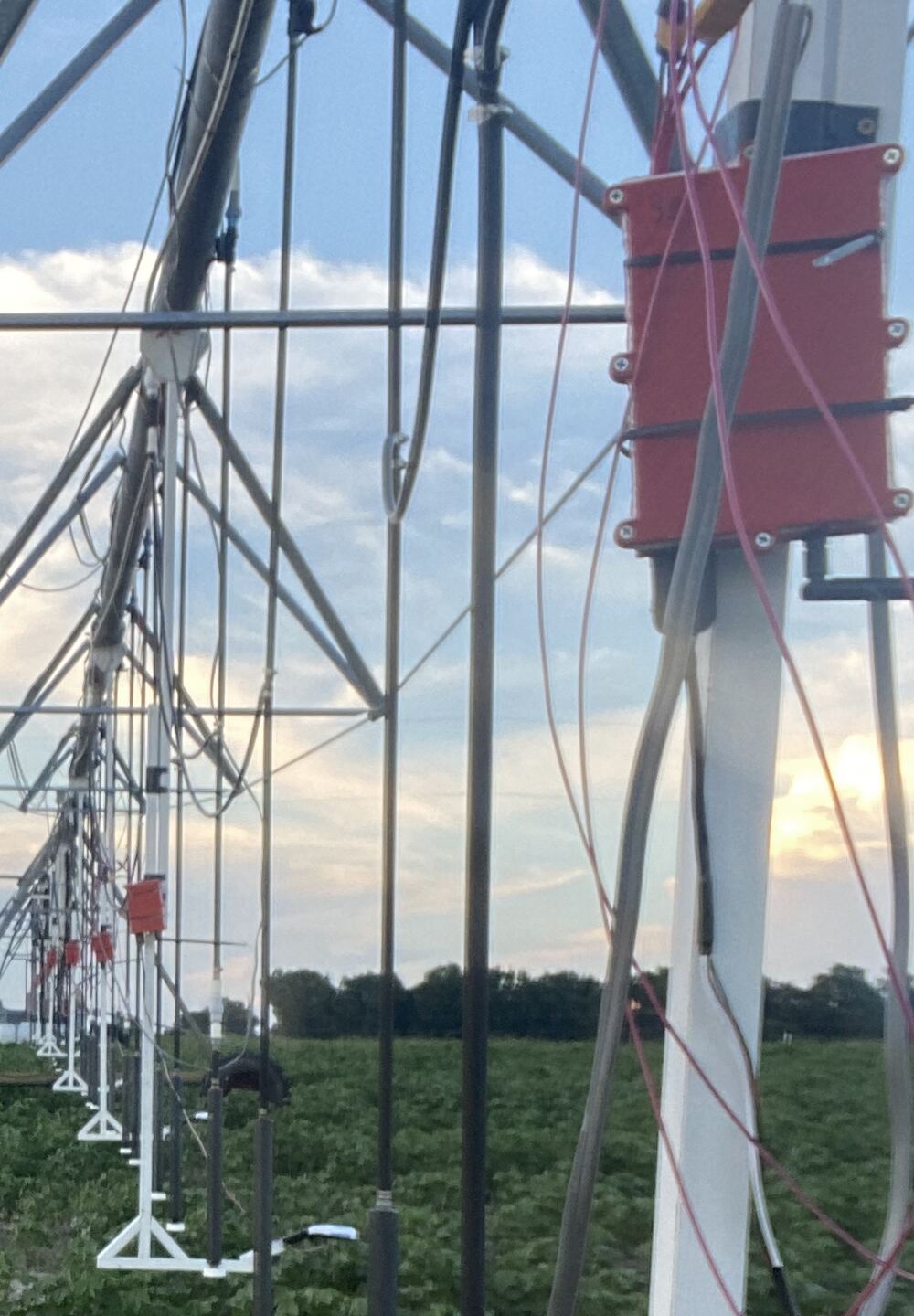 An instrumented linear-move irrigation machine with drop tubes, control enclosures, and sensor wiring installed across the span.